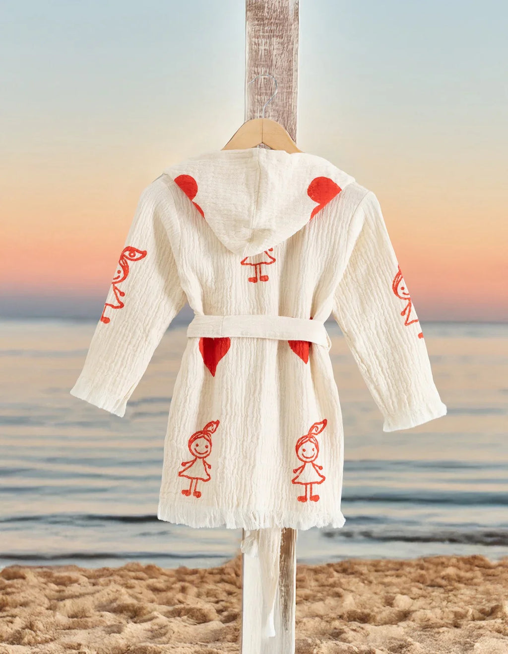 Kindermantel mit roten Herzen und Figuren am Strand