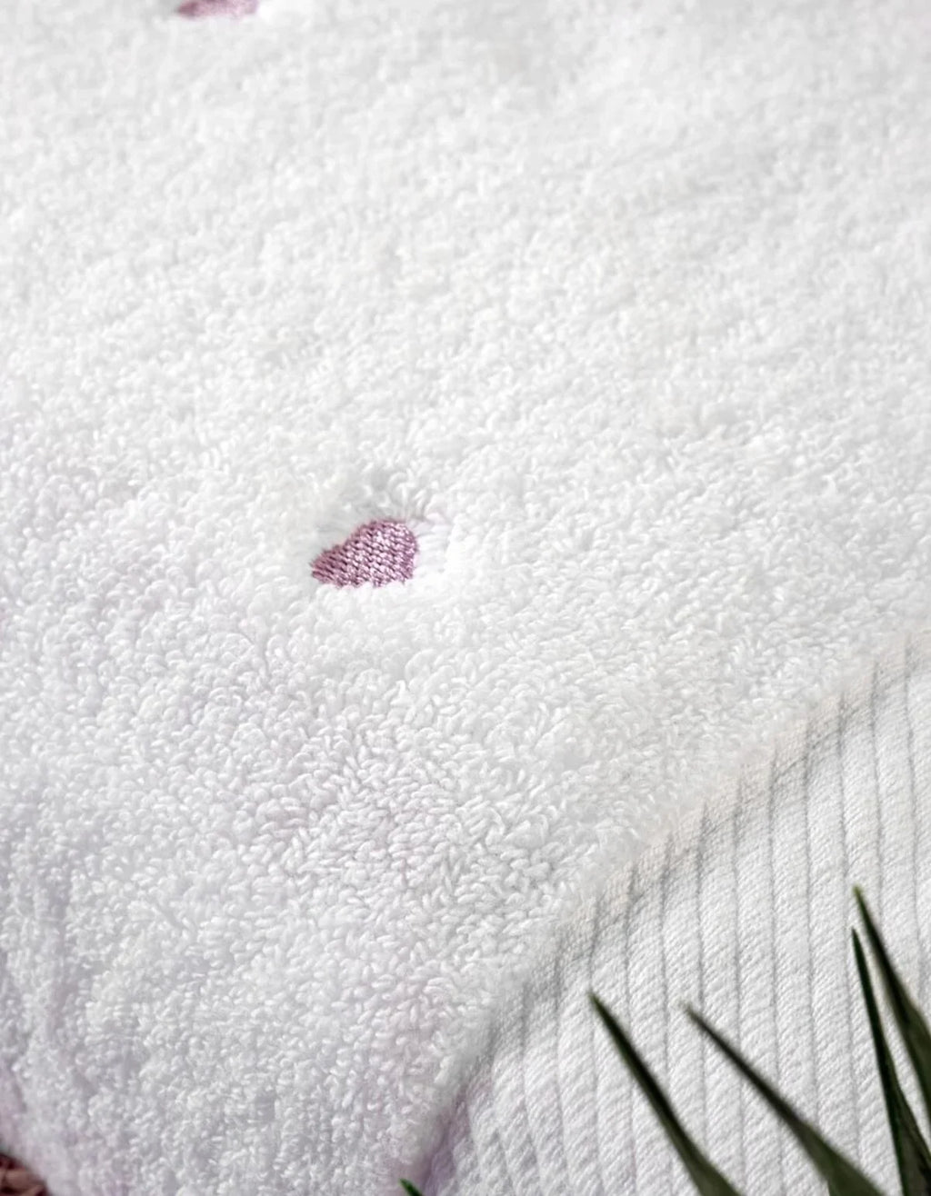 Weißer waschbarer Teppich mit lila Herz-Motiv und grünen Pflanzenblättern