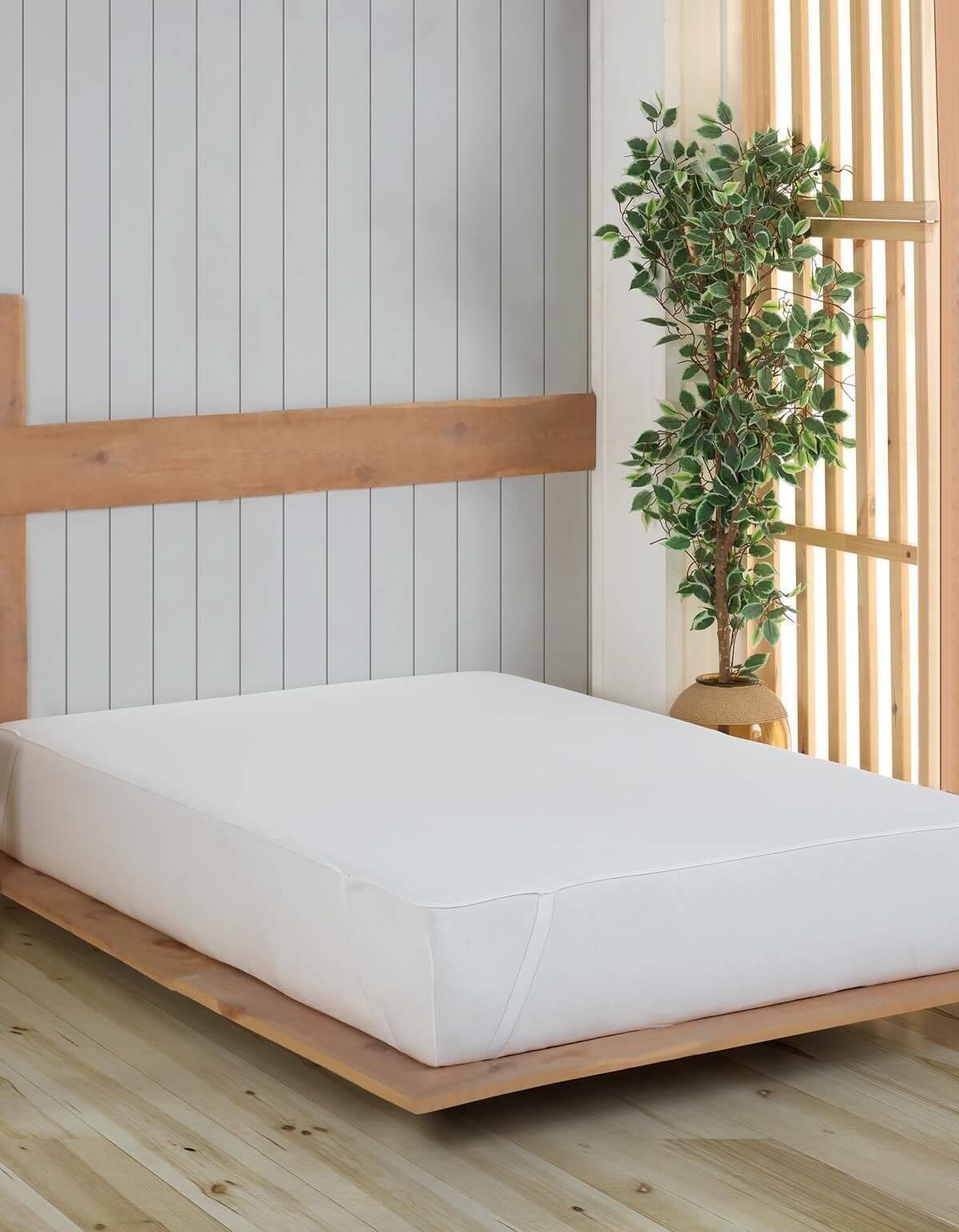 Weißer waschbarer Matratzenbezug auf Holzbett im modernen Schlafzimmer