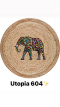 Round natural fiber rug with colorful floral elephant design, model Utopia 604.