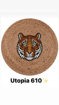 Round braided natural fiber rug with colorful tiger head design in center.