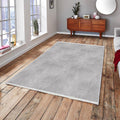 Light grey washable rug on wooden floor in modern living room with large windows